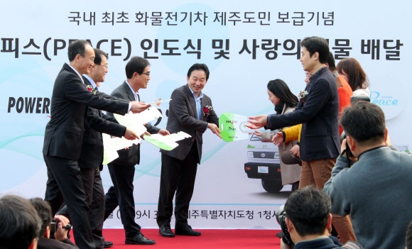 원희룡(왼쪽 네 번째) 제주지사 등이 24일 도청에서 도시 및 농촌 생계형 화물전기차 ‘라보 피스’를 상징하는 모형 키를 보급대상자 5명에게 전달하고 있다. 제주 연합뉴스