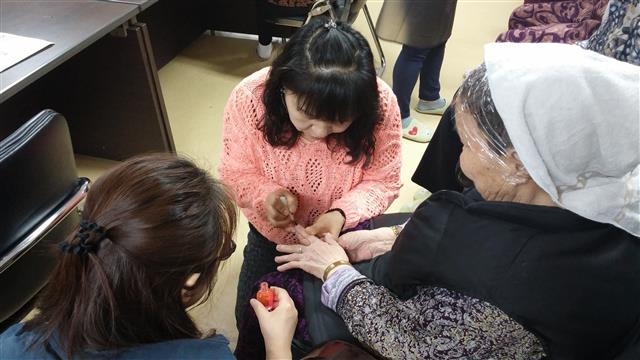 송파구 장지동 송파파인타운 9단지 주민들로 이뤄진 ‘우리 동네 예뻐지는 머리방’ 회원들이 지역 어르신의 손톱을 예쁘게 정리해 주고 있다.
