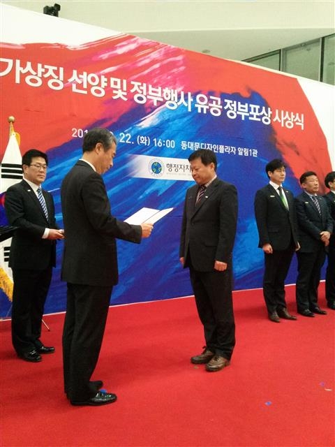 지난 22일 국가상징 선양 유공 정부포상 시상식에서 정주영(오른쪽) 자치행정과장이 대통령 표창을 받고 있다. 강북구 제공 