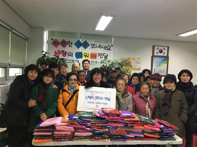 신창마을 시끌벅적 사랑방 회원들이 지난 24일 지역 노인들에게 직접 뜬 목도리를 전달하고 기념촬영을 하고 있다.  도봉구 제공