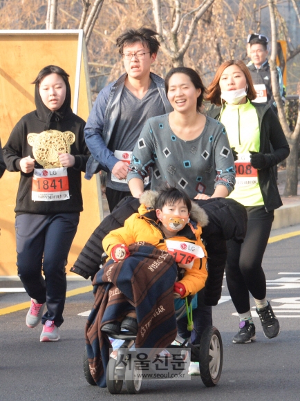 2016년 한 해의 시작을 기념한 ‘서울신문 해피 뉴런’ 10㎞ 마라톤 대회에는 가족 단위 참가자들이 많아 보는 사람들의 마음을 훈훈하게 만들었다. 한 여성이 아들이 탄 유모차를 즐거운 표정으로 밀며 달리고 있다. 김명국 전문기자 daunso@seoul.co.kr