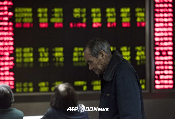 7일(현지시간) 중국 베이징의 한 객장에서 투자자들이 시세 전광판을 바라보고 있다.  이날 중국 증시가 7% 이상 폭락하면서 개장 30분만에 거래가 중단됐다. ⓒ AFPBBNews=News1