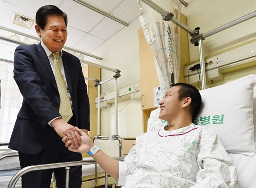 이상운(왼쪽) 효성 부회장이 지난 6일 서울 이대목동병원에서 치료를 받고 있는 베트남 청년의 손을 잡으며 위로를 건네고 있다.  효성 제공 