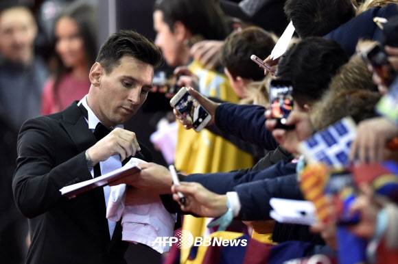 리오넬 메시가 11일(현지시간) 스위스 취리히 콩그레스하우스에서 열린 2015 FIFA 발롱도르 시상식 레드 카펫 행사에 모여든 팬들에게 사인을 해주고 있다. ⓒ AFPBBNews=News1