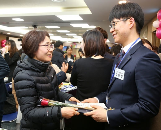 지난 15일 서울 서초구청의 ‘2016 새내기 공무원 임용식’에서 신규 임용자들이 가족들에게 감사의 꽃과 임용장을 전달하고 있다.  