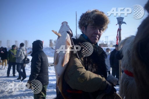 　‘빙덩제’(氷燈節)가 열리고 있는 중국 동북부 헤이룽장성 하얼빈 헤이허에서 한 시민이 낚은 생선을 자랑하듯 어깨에 메고 있다. ⓒ AFPBBNews=News1  