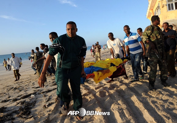 소말리아 해변 식당 총기난사. 22일(현지시간) 소말리아 수도 모가디슈의 리도 비치에서 총기난사 및 폭탄 테러가 발생했다. 주민들이 해변에서 이번 테러로 숨진 시신을 옮기고 있다. ⓒ AFPBBNews=News1