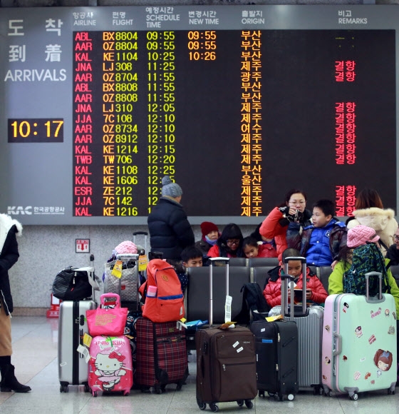 제주에 한파와 폭설, 강한 바람이 불면서 항공기 운항 중단이 계속된 24일 서울 김포공항 국내선 청사에 결항 안내문이 게시되고 있다.  연합뉴스