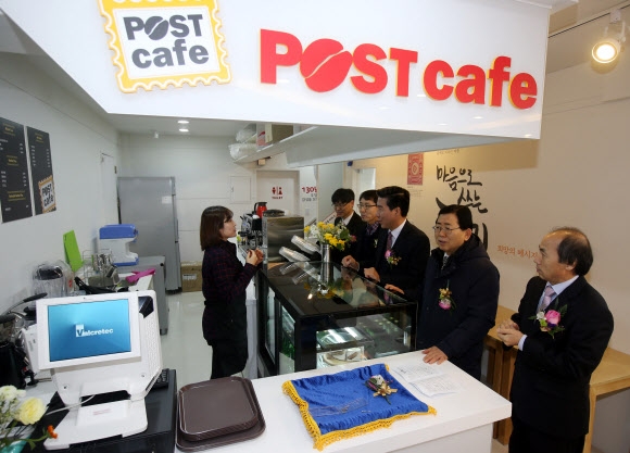 오래된 소형 우체국을 리모델링해 ‘라이브 포스트’로 바꾼 서울 혜화동 라이브 포스트 내 카페에서 손님들이 차를 주문하고 있다. 이 카페에서는 다음 달부터 오후 11시까지 소포를 접수시킬 수 있다. 연합뉴스