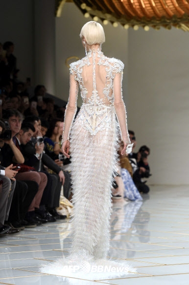 27일(현지시간) 프랑스 파리에서 열린 2016 봄/여름 오트 쿠튀르 컬렉션 무대에서 디자이너 궈 페이(Guo Pei)의 의상을 입은 모델이 런웨이를 걷고 있다.<br>ⓒ AFPBBNews=News1