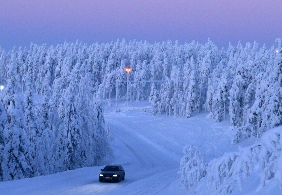 눈 쌓인 침엽수림 사이를 달리는 자동차. 길은 틀림없이 얼어붙었는데 차는 희한하게도 미끄러짐이 없었다.