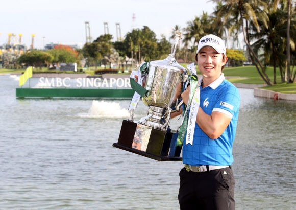송영한이 1일 싱가포르 센토사 골프클럽 세라퐁 코스에서 열린 아시아투어 싱가포르오픈 4라운드 잔여 경기에서 남은 세 홀을 모두 파세이브하며 우승을 차지한 뒤 트로피를 든 채 환하게 웃고 있다. 신한금융그룹 제공