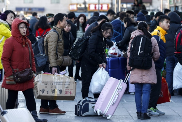 춘제 연휴 하루 전날인 5일 베이징역이 선물 꾸러미를 든 귀성객들로 북새통을 이루고 있다. 베이징 EPA 연합뉴스