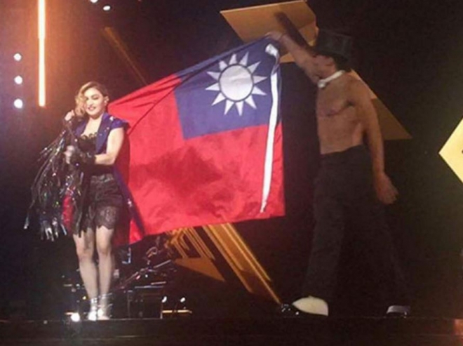 팝스타 마돈나가 지난 4일(현지시간) 대만 타이베이에서 ’글로벌 레벨 하트 투어’ 공연 도중 앙코르곡을 부르면서 대만 국기를 어깨에 걸쳤다가 논란을 불렀다. 사진은 어깨 뒤로 대만 국기를 펼친 마돈나 << 인디펜던트 캡처 >>