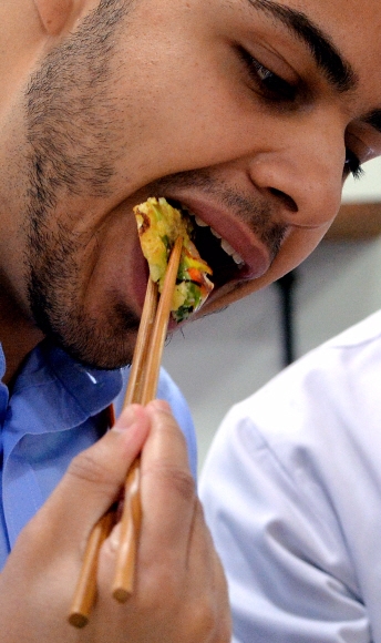 외국인 관광객이 직접 만든 해물파전을 서투른 젓가락질을 해 가며 맛보고 있다.