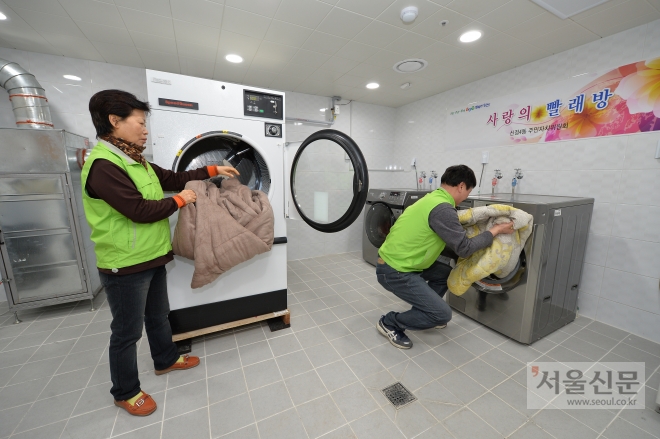 지난 24일 문을 연 서울 양천구 신청4동 통합청사에 마련된 사랑의 빨래방에서 봉사자들이 빨래를 하고 있다. 양천구 제공 