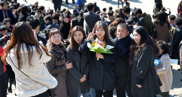 26일 서울 서대문구 신촌동 연세대학교 노천극장에서 열린 입학식이 끝난 후 축하 꽃다발을 든 신입생이 가족들과 함께 사진을 찍고 있다. 2016. 2. 26 손형준 기자 boltagoo@seoul.co.kr