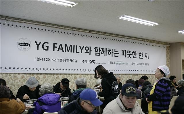 마포구에 위치한 대형 연예기획사인 YG엔터테인먼트 직원들이 성산종합사회복지관에서 노인들에게 식사 대접을 하고 있다. 마포구 제공