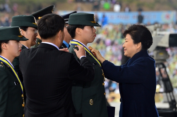 박근혜 대통령이 4일 충남 계룡시 계룡대에서 열린 ’2016년 장교 합동 임관식’에서 가족과 함께 계급장을 달아 주고 있다. 청와대사진기자단