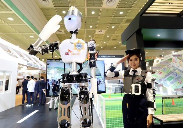지난해 5월 서울 강남구 코엑스에서 열린 국내 최대 ICT전시회 ‘월드 IT쇼 2015’에서 SK텔레콤이 개발한 5G 경찰 로봇이 통제요원의 수신호를 따라 인사하고 있다.  SK텔레콤 제공