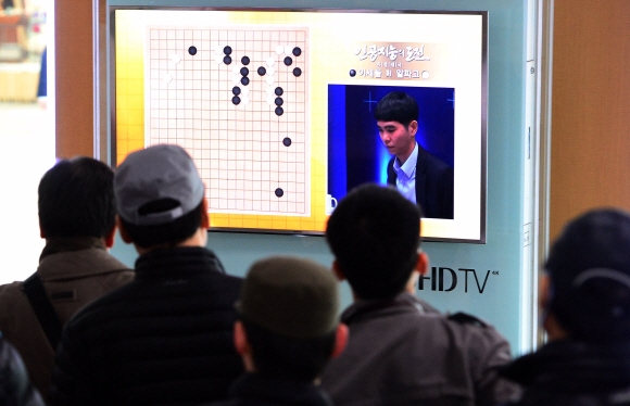 이세돌 9단과 구글 인공지능(AI) 바둑프로그램 알파고의 세기의 대결이 시작된 9일 시민들이 서울역 대합실에서 텔레비전 중계를 지켜보고 있다.  박윤슬 기자 seul@seoul.co.kr