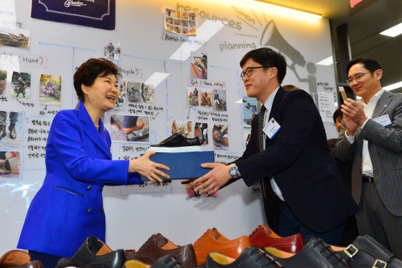 박근혜 대통령이 10일 오전 대구창조경제혁신센터방문해 입주기업 부스를 둘러보다 구두장인이 만든 구두를 선물받고 있다. 오른쪽은 이재용 삼성전자 부회장.  청와대사진기자단