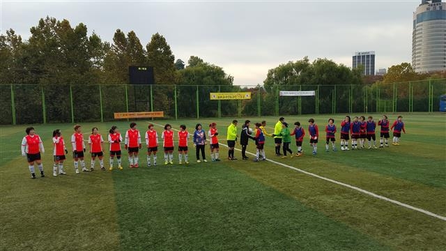 마포구 여성축구교실 회원들(중앙선 왼쪽)이 지난해 11월 1일 서울 송파구 여성 축구장에서 중랑구 여성축구교실 회원들과 경기를 하기 전 인사하는 모습. 마포구 제공
