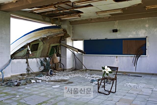 동일본 대지진과 쓰나미로 폐허가 된 후쿠시마현의 한 초등학교 교실 의자에 설치된 가타키리 아쓰노부의 작품. 창문으로 뒤집힌 배가 보인다.