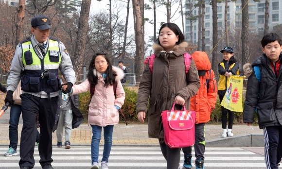 14일 오전 송파경찰서 신천파출소 경찰관이 신학기를 맞아 안전한 등굣길을 위해 차량이 많이 지나는 잠실초등학교 앞 교통정리와 함께 어린이들의 등교를 돕고 있다. 2016.03.14 강성남 선임기자 snk@seoul.co.kr