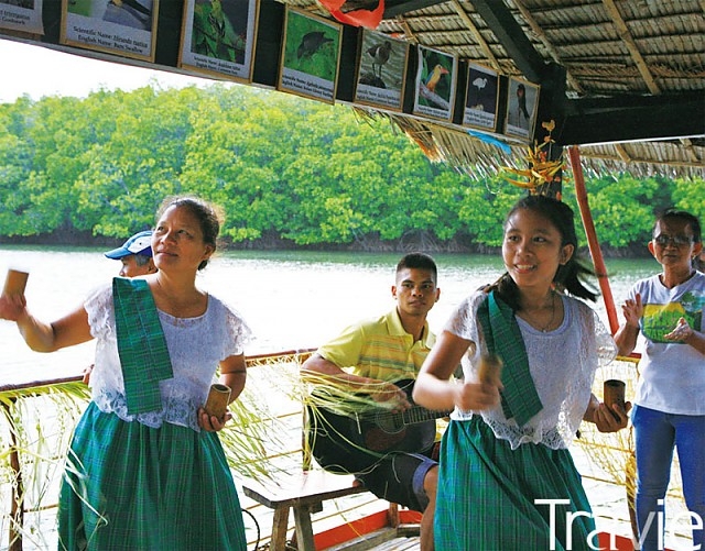 배 위에서 마을 주민들이 외지인을 환영하는 노래와 춤을 선보인다
