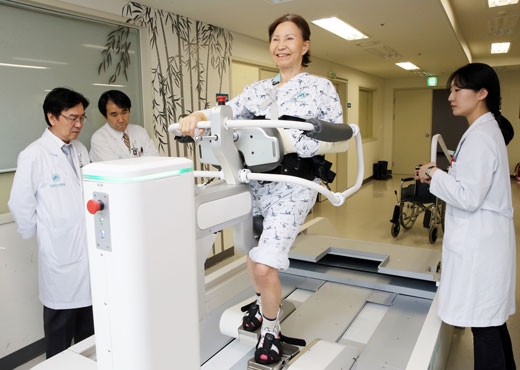 17일 서울아산병원에서 현대중공업의 보행재활로봇을 활용해 환자를 치료하고 있다.   현대중공업 제공 