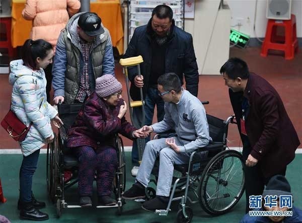황샤오융의 노모가 손자 대역을 자처한 왕펑의 손을 잡고 기뻐하고 있다.신화통신 홈페이지 캡쳐