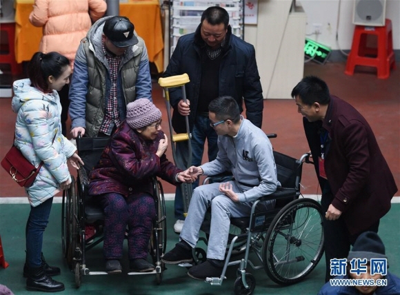 황샤오융의 노모가 손자 대역을 자처한 왕펑의 손을 잡고 기뻐하고 있다. 신화통신 홈페이지 캡처