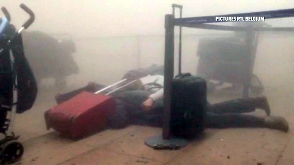 22일(현지시간) 발생한 벨기에 브뤼셀 공항 폭탄 테러로 공항 청사 내부에 뿌연 연기가 가득 차 있고 일부 여행객들이 바닥에 쓰러져 있다. AFP 연합뉴스