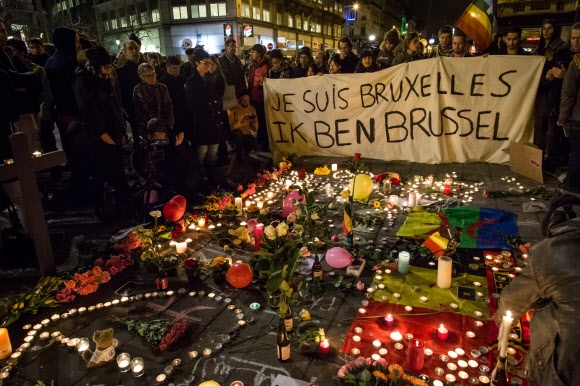 22일(현지시간) 벨기에 브뤼셀 부르스 광장에서 시민들이 촛불과 꽃다발을 바치며 희생자들을 추모하고 있다. AFP 연합뉴스