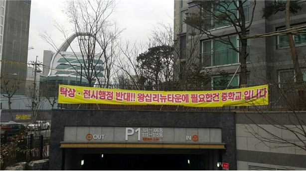 서울시 왕십리 뉴타운 입구에 고등학교 대신 중학교 설립을 요구하는 현수막이 걸려있다.