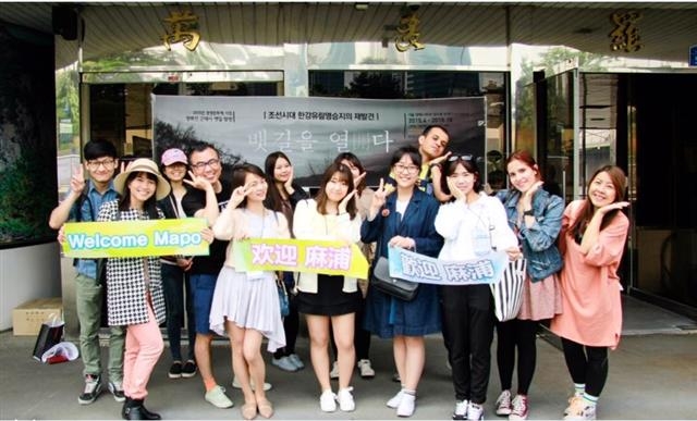 지난해 마포구 글로벌 서포터즈로 활동했던 외국인들이 양화진 뱃길탐방에 참여한 뒤 마포구 홍보 문구를 들고 활짝 웃고 있는 모습. 마포구 제공