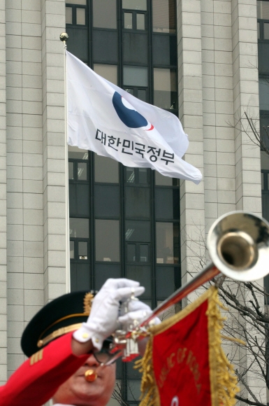 29일 서울 세종로 정부서울청사에서 열린 새 정부기 게양식에서 ’무궁화’에서 ’태극’ 도안으로 바뀐 새 정부기가 바람에 펄럭이고 있다. 2016.3.29안주영기자 jya@seoul.co.kr