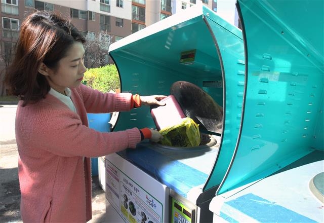 동작구의 한 주민이 4일 아파트 단지 내 가구별 종량기기에 음식물 쓰레기를 버리고 있다.  동작구 제공