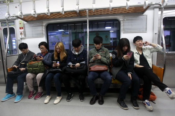  5일 서울의 한 지하철 안에서 승객 모두가 자신의 휴대전화를 사용하고 있는 모습. AP 연합뉴스