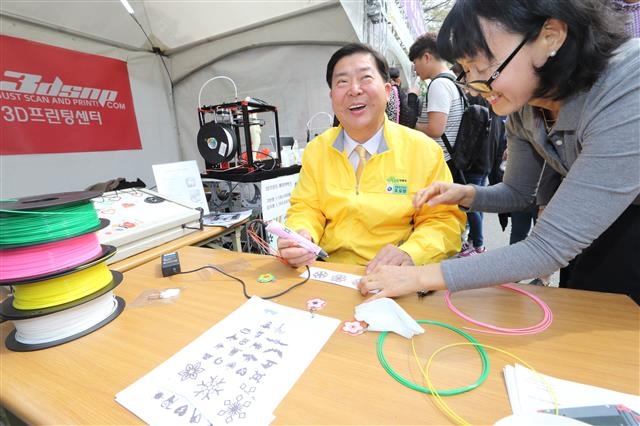 6일 영등포구 여의도 봄꽃축제 현장에 설치된 우수 중소·벤처기업 박람회에서 조길형(왼쪽) 영등포구청장이 3D펜을 시연하고 있다.  영등포구 제공 
