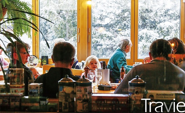 눈 내리는 창 밖을 보면서 식사를 즐기는 사람들. 스위스 겨울 여행의 낭만이 녹아 있다