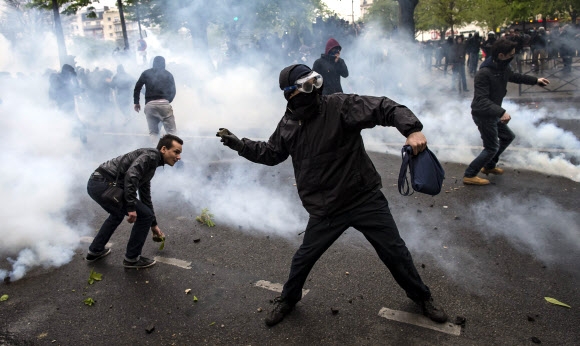 9일(현지시간) 프랑스 파리에서 시위대가 최루탄을 쏘는 경찰을 향해 돌을 던지며 격렬한 시위를 벌이고 있다. 파리 EPA 연합뉴스