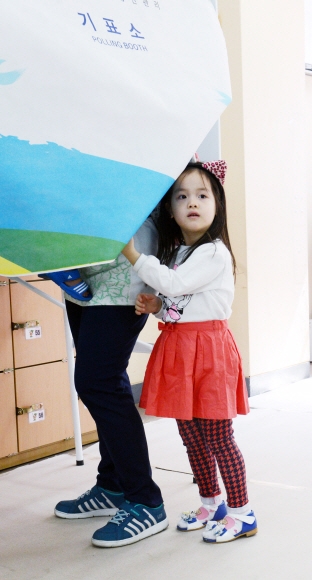 제20대 국회의원 선거날인 13일 오전 서울 은평구 진관동 제3투표소에서 한 아이가 엄마를 따라 기표소로 들어가고 있다.안주영 기자 jya@seoul.co.kr
