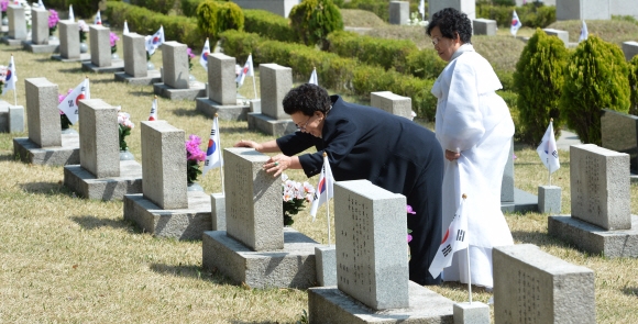 4.19 혁명을 하루 앞 둔 18일 서울 강북구 수유동 국립4.19민주묘지를 찾은 한 유족이 남편 묘의 비석을 붙잡고 ’다시 오겠다’며 인사를 건네고 있다. 2016. 4. 18 손형준 기자 boltagoo@seoul.co.kr