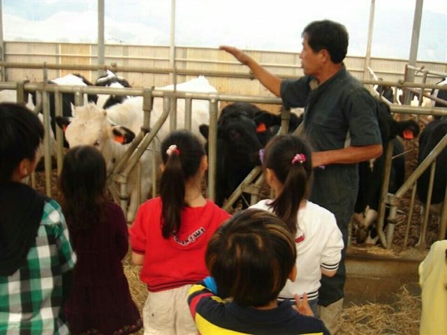 ‘은아목장의 남자’ 김상덕씨가 목장 체험프로그램에 참가한 어린이들에게 젖소에 대해 설명하고 있다. 은아목장 제공
