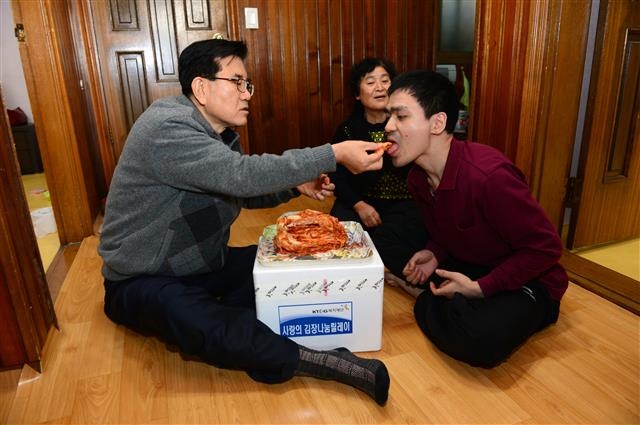 유덕열(왼쪽) 동대문구청장이 ‘사랑의 김장나눔 릴레이’를 하면서 어려운 지역주민에게 김장김치를 손수 먹여주고 있다.