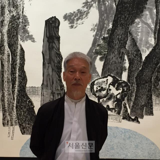 소산 박대성 화백이 화업 50년 기념전에 출품한 소나무 작품 ‘솔거의 노래’ 앞에서 포즈를 취하고 있다.