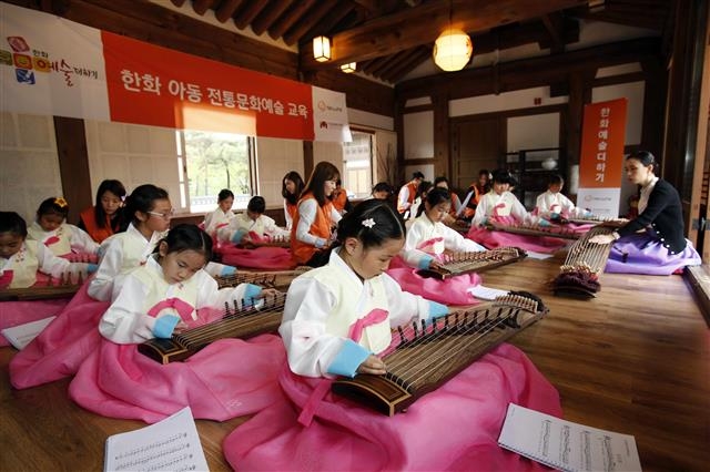 지난 21일 서울 남산국악당 체험실에서 ‘한화예술더하기’ 프로그램에 참여한 초등학생들이 가야금 연주를 하고 있다. 한화 제공