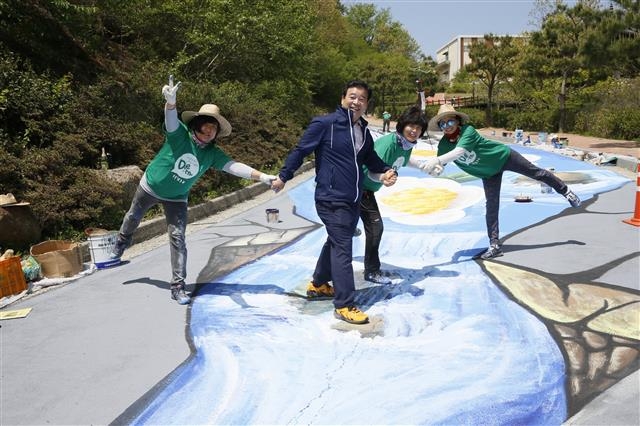 이용부 보성군수가 보성다향대축제가 열리는 한국차문화공원을 찾아 트릭아트 작업을 하고 있는 사회적기업 팀원들과 활짝 웃으며 포즈를 취하고 있다. 보성군 제공
